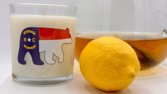North Carolina Sweet Tea Luxury Candle clear vessel with NC Flag and Black Bear with pitcher of sweet tea and lemon