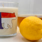 North Carolina Sweet Tea Luxury Candle clear vessel with NC Flag and Black Bear with pitcher of sweet tea and lemon 